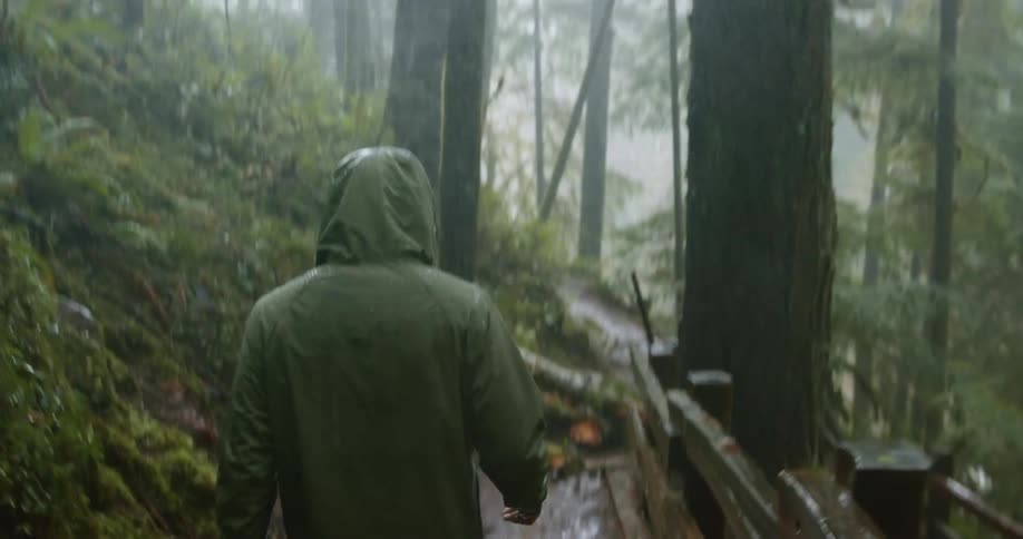 A man is hiking outdoors in the rain