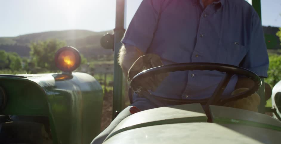 A farmer driving a tractor on his land
