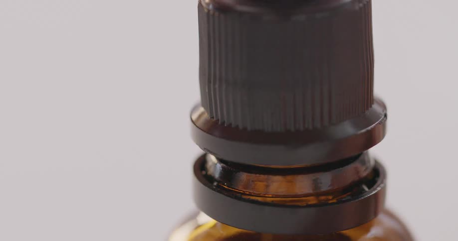 Close up of a small glass bottle with a dropper cap