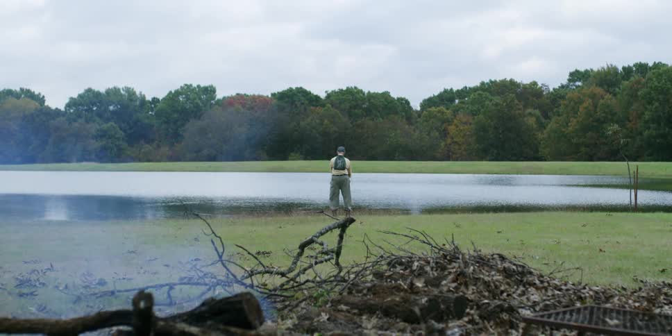 A man stands on the shore and fishes