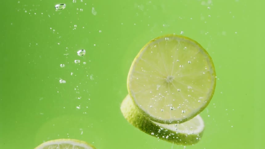 Lemon and lime slices falling in to water