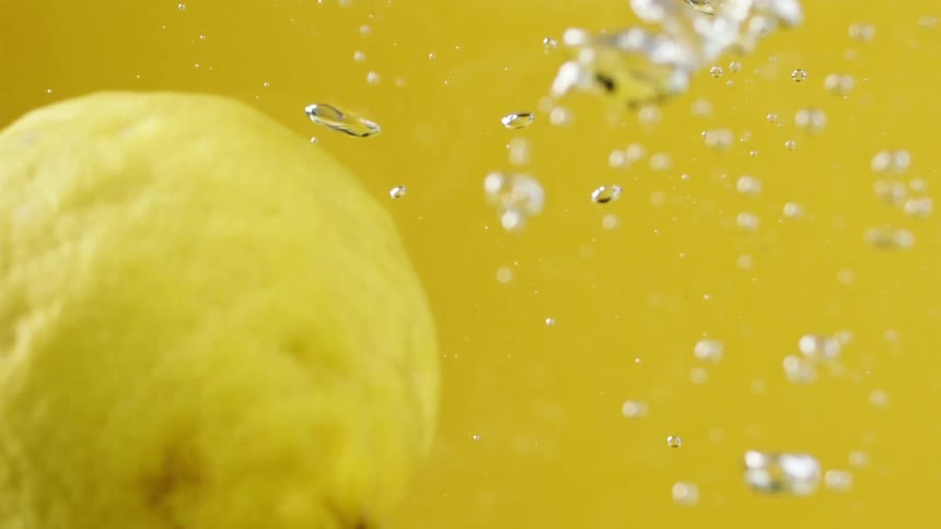 Lemons dropping in water and floating to the top