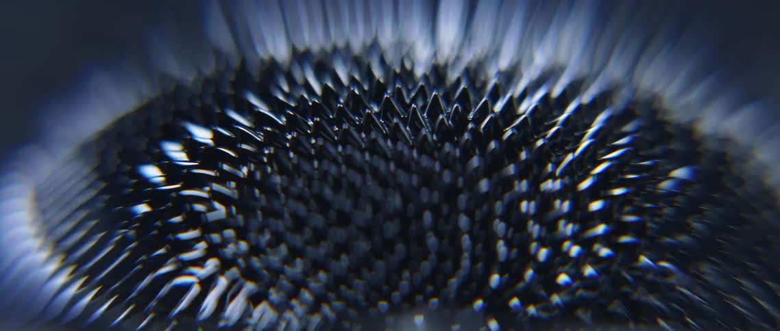 A magnet turns magnetic sand into several small peaks on a circle pattern that jiggles