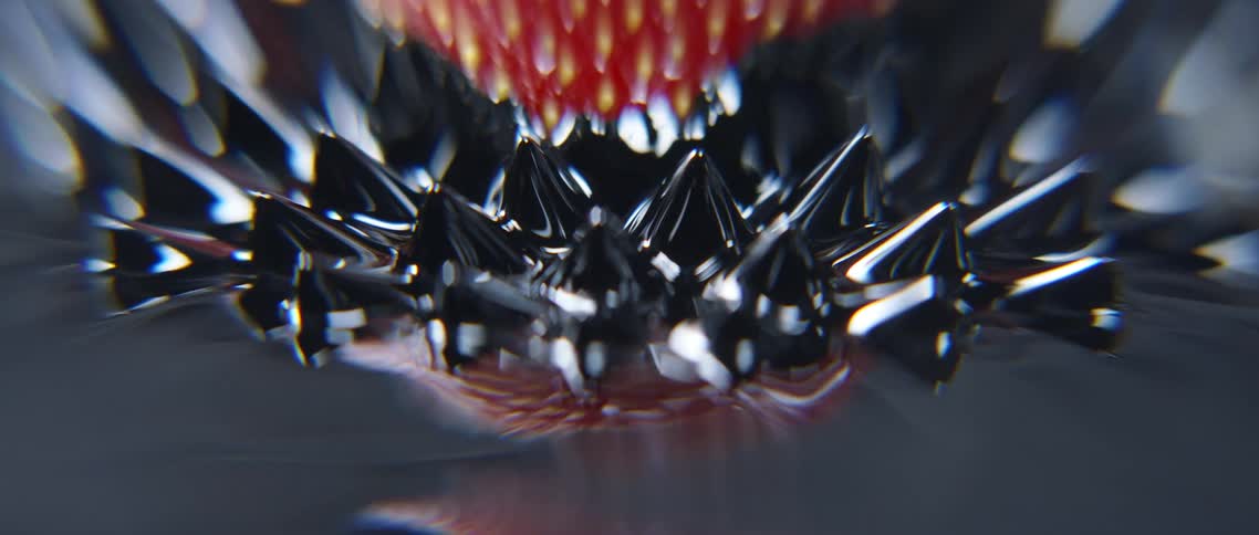 Abstract footage of rubber bristles rising and enveloping a strawberry