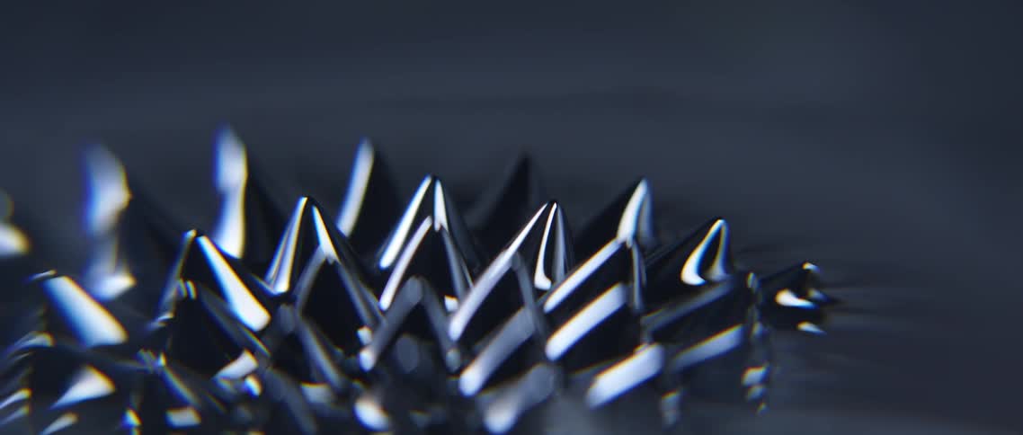 Close up of spikes of ferrofluid liquid reacting to a magnetic field