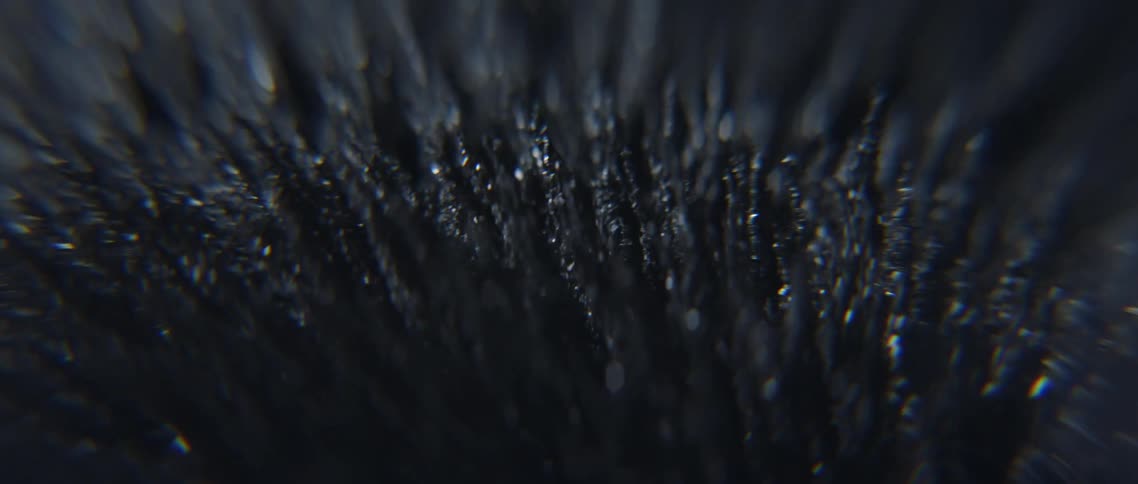 Close up of iron filings moving under a magnetic field