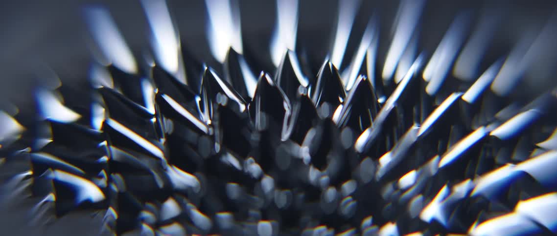 A chrome liquid rises up to form peaks and a spiked pattern