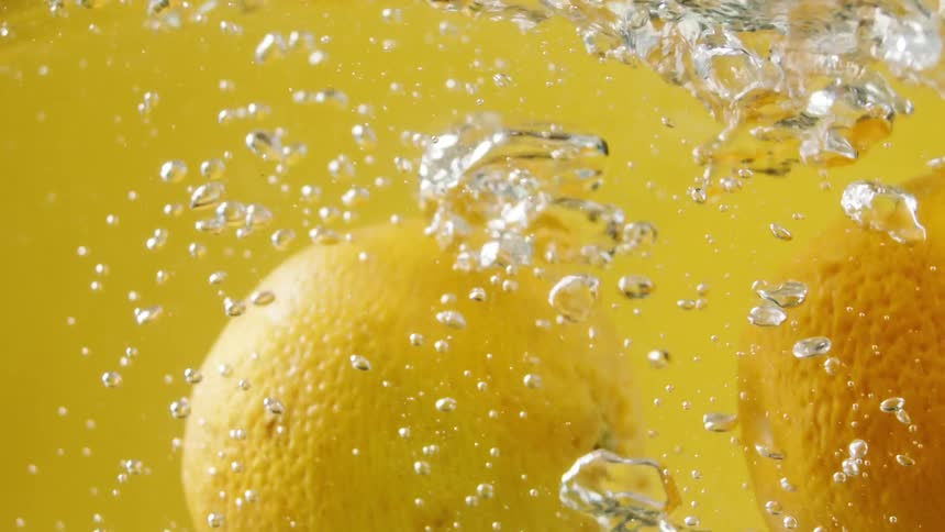 Two lemons are in a glass of water