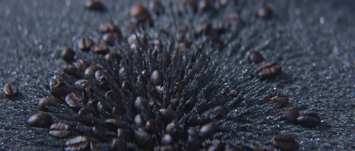 Coffee beans fall into a pit created by moving magnetic sand