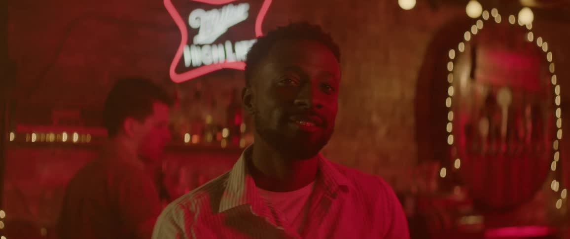 A man smiles and walks from the bar