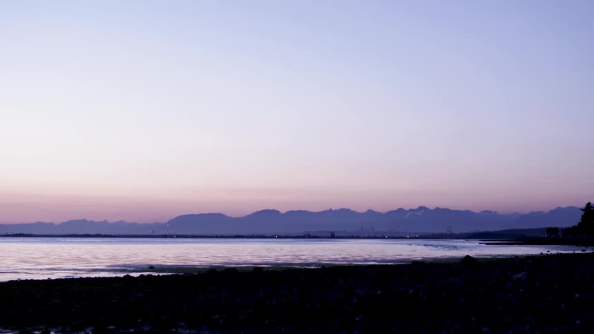 The water slowly hits the shore at sunset