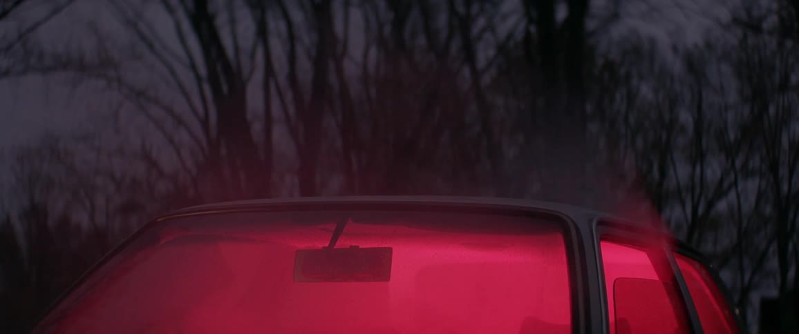 Smoke billows out of a car window, glowing red from inside