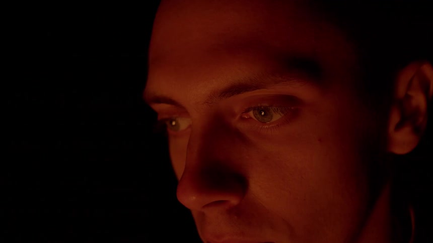 A man stares into a camp fire