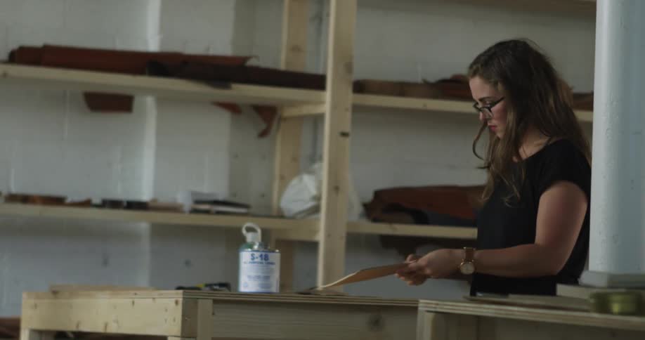 A woman stands next to a table in a workshop