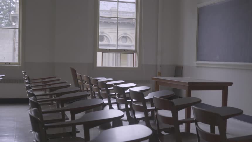 Rows of empty wood desks in a school classroom