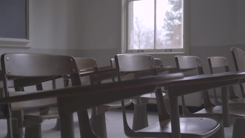 Rows of stationary desks in a classroom during the day