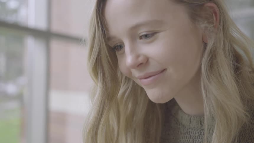 A young girl smiles inside a building