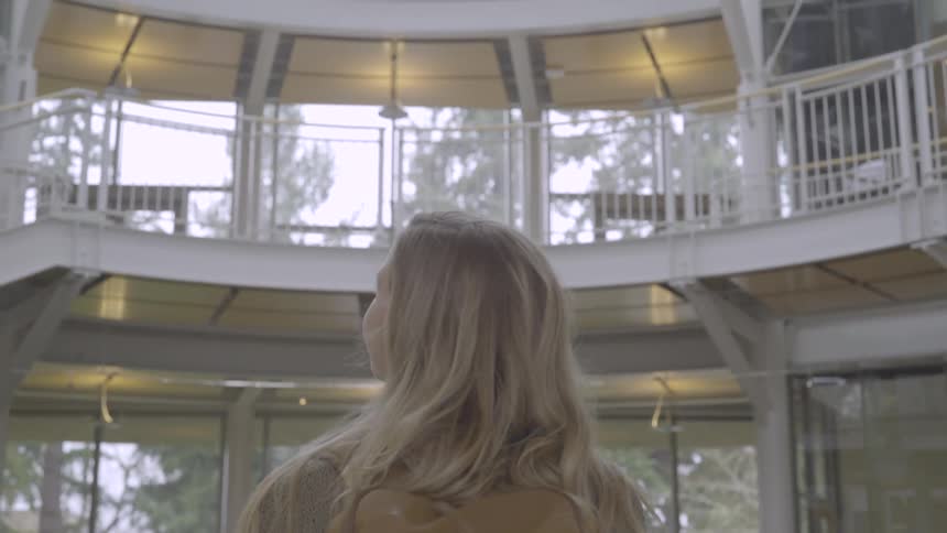 A woman looks around the levels of the building inside