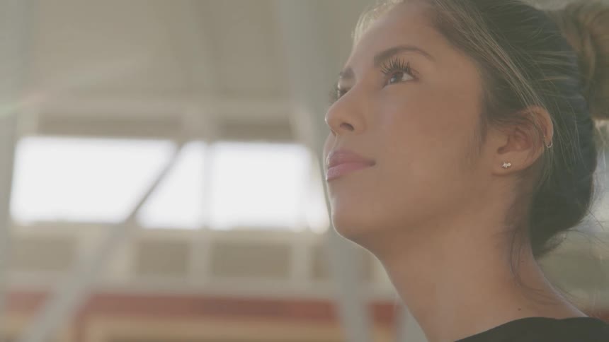 Woman blinks her eyes as she stands inside of a garage