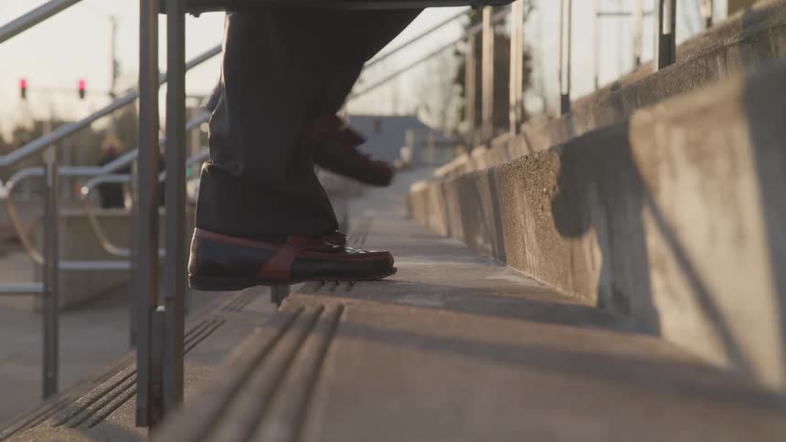A man walks up stairs outside in a city