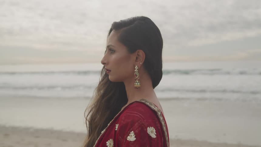 A woman is wearing a dress at the beach