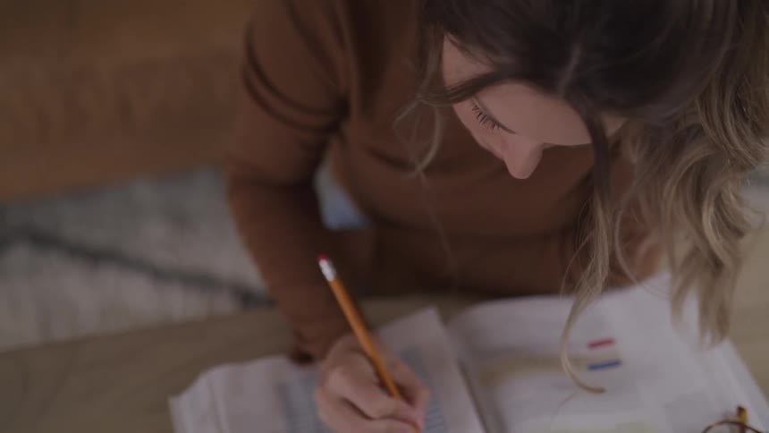 Woman with a brown sweater sits at a table does a test in a room
