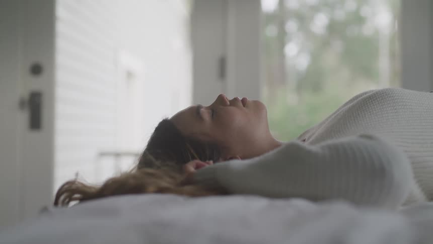A woman is laying on a bed indoors