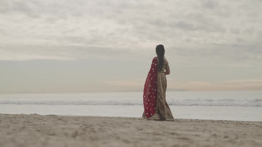 A woman is walking on the beach