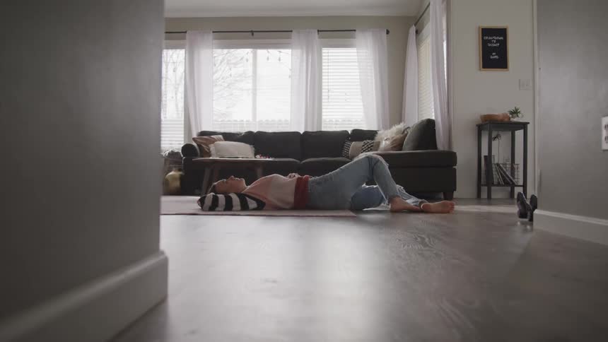 A teenage girl lying on her living room floor