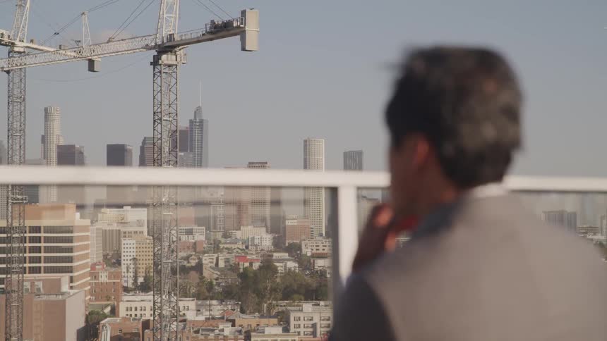 Man looks out at a construction site in the city