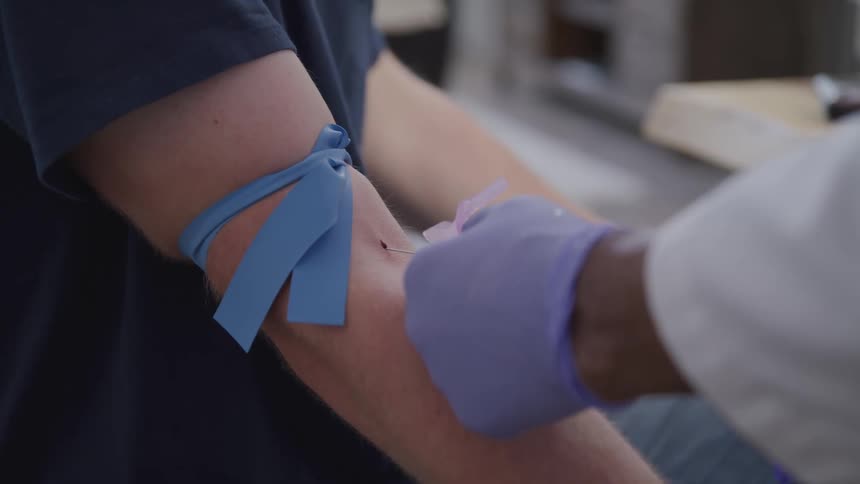 A doctor is injecting a patient with a needle