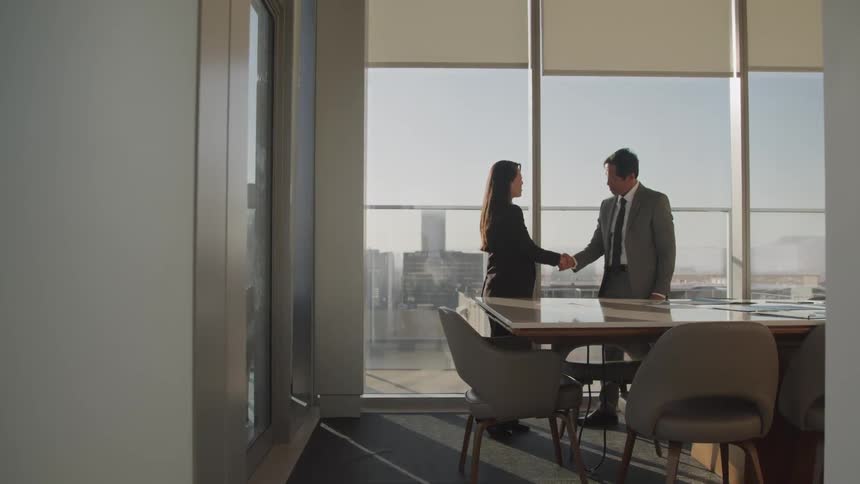 Businessman and businesswoman shake hands in the conference room