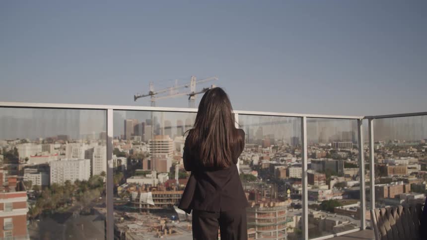 A woman is standing outdoors in a downtown city