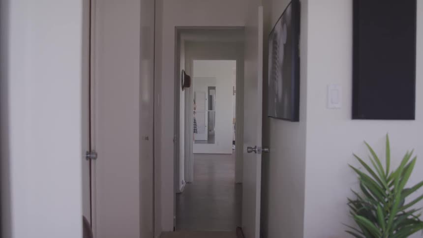 Asian teenager girl with a pink shirt and a skirt paces up and down a room at home