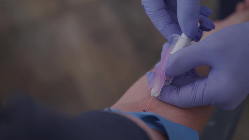 A nurse draws blood from a patient