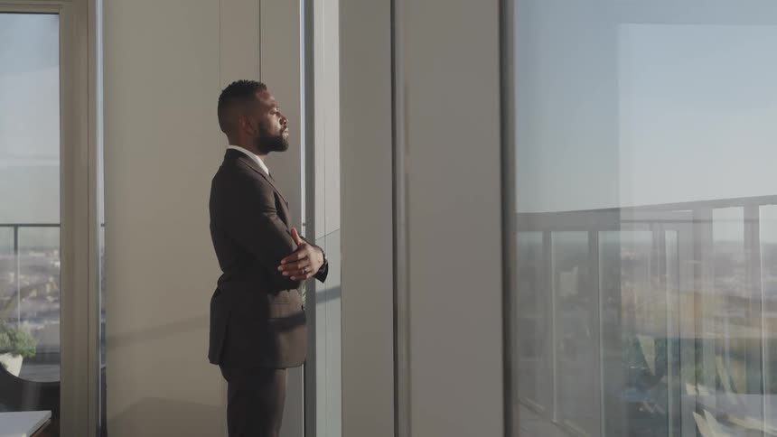 A man is wearing a suit and standing in an office building