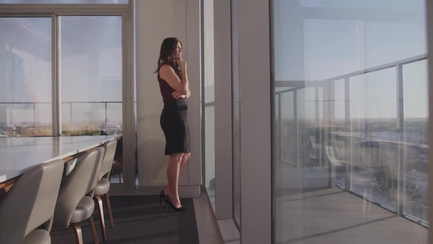 A woman is standing in an office building in a downtown city