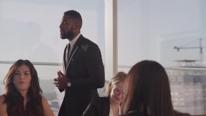 Bearded man in a business suit talks on a meeting in an office at sunset