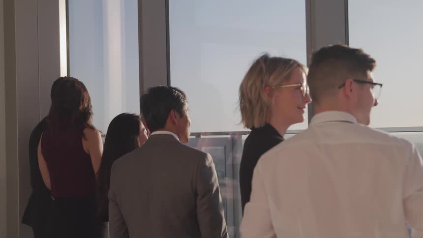 Group of business people looking at the city skyline from an office window