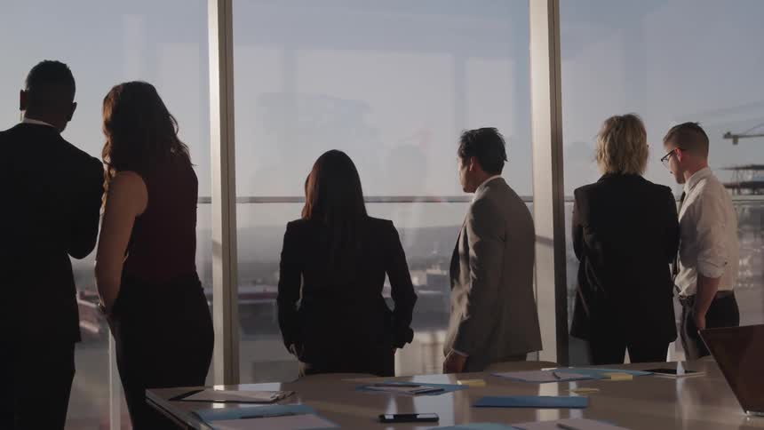 Business people look out the office windows in the conference room