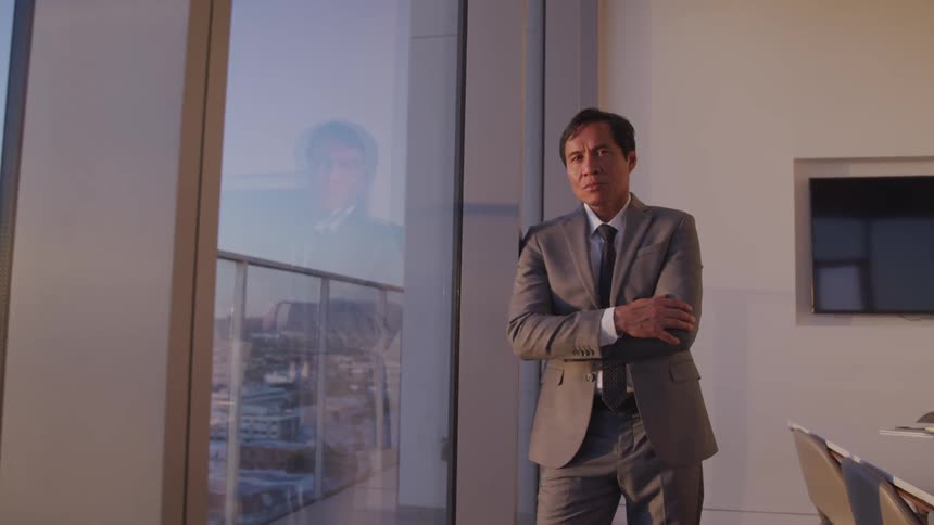 A man is wearing a suit and standing in an office