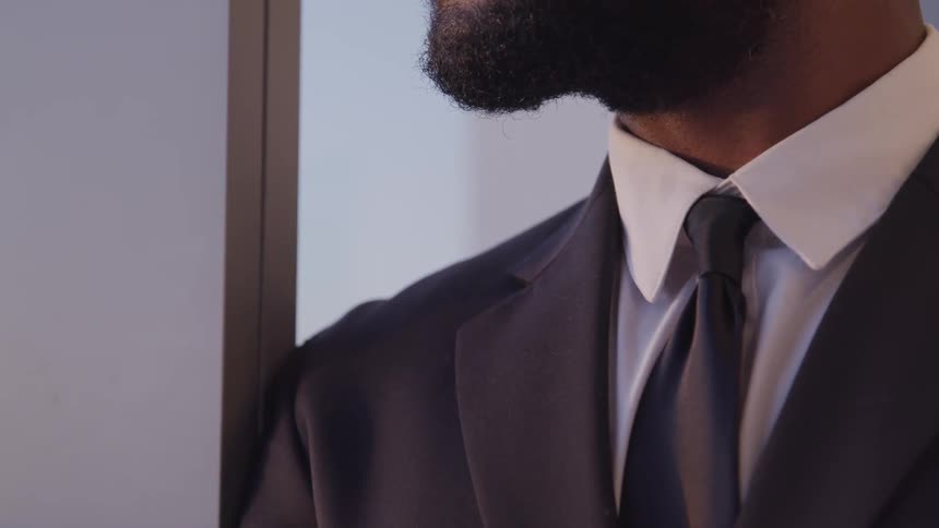 A man wearing a suit is standing indoors