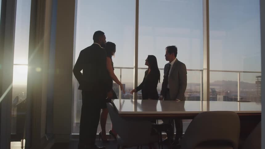 Business people shake hands in conference room