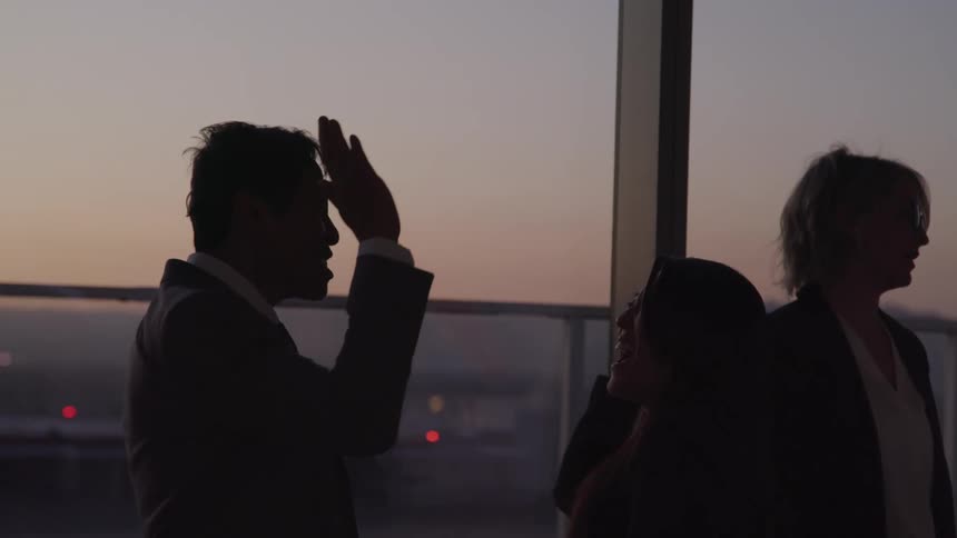 A man and woman at a gathering high five one another