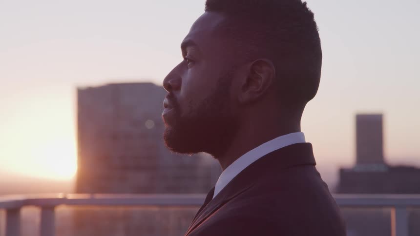 A man is watching the sunrise on the roof of the building