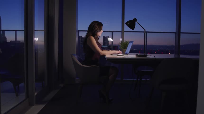 A woman is working in an office at night