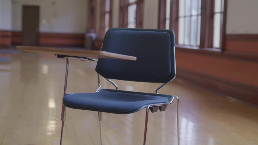An desk sitting in an empty room in a school