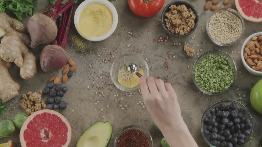 A person measures out healthy ingredients and puts them in a glass bowl