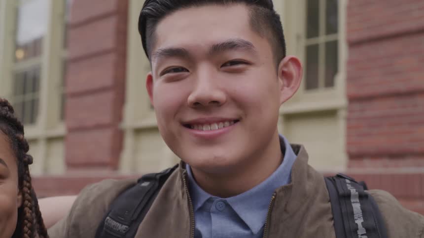 A black female and a male asian standing together and smiling