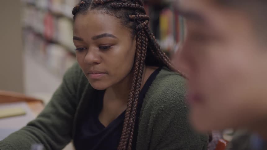 Young woman sitting in a study group on the library